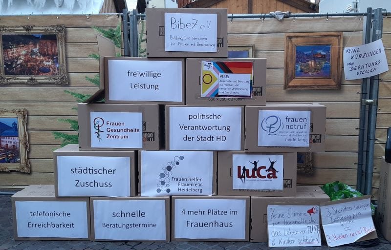 Kartons mit Logos der beteiligten Vereine und deren Forderungen bei der Kundgebung am 27.11.2025; aufgebaut als Pyramide
